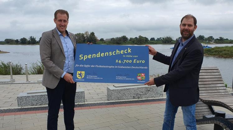 Einen symbolträchtigen Ort haben sich Dennis Neumann (l.) und Andreas Gehrke gewählt, um die Spendensumme für die Flutopfer im Südwesten Deutschlands zu präsentieren. Der Hafen von Bleckede an der Elbe hat auch schon einige Hochwasser erlebt.