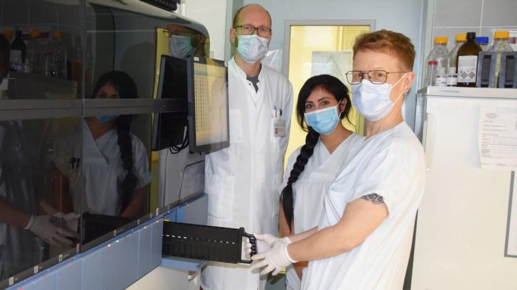 Dr. Philipp Warnke (v.l.), Shaima Almansor aus der Sektion für Endokrinologie, die als Medizinisch-Technische Assistentin im Labor unterstützt, und Nicole Deinet am neuesten PCR-Gerät.