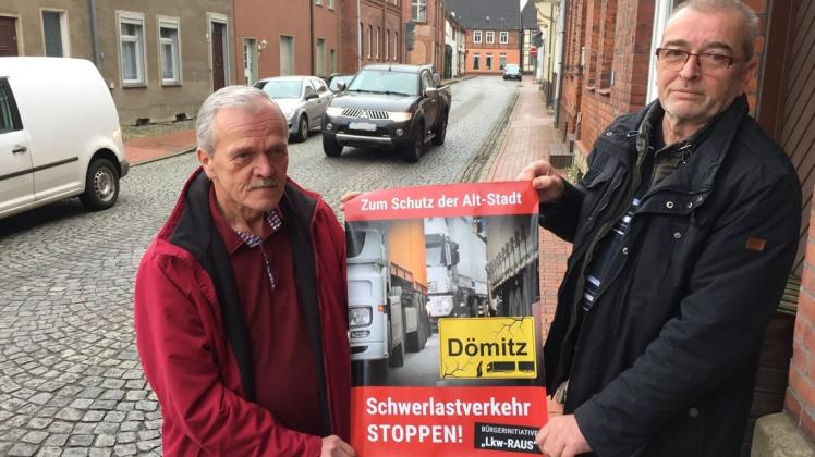 Mit diesen Plakaten wollen Reimund Scheper (r.), Volkmar Günther und andere geplagte Dömitzer auf das Problem mit dem Schwerlastverkehr in ihrer Altstadt aufmerksam machen.