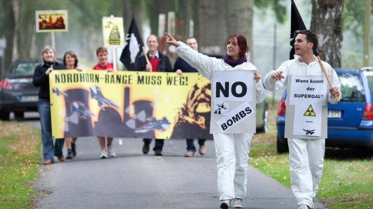 Mitglieder der Bürgerinitiative "Notgemeinschaft Nordhorn Range" protestieren in Nordhorn 
 mit Transparenten gegen den Bombenabwurfplatz "Nordhorn Range".