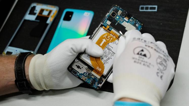Reparatur eines Mobiltelefones in der Werkstatt der Komsa AG. Verbraucherschützer fordern die Bundesregierung dazu auf, das geplante Recht auf Reparatur bis Mitte März auf den Weg zu bringen.