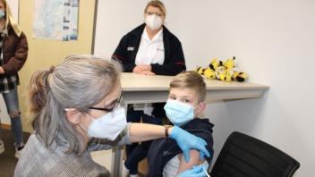 „Hat gar nicht weh getan“. Der 10-jährige Mika aus Gersten wird von Ärztin Regina Alting geimpft.  Anja Gersema vom Impfzentrum Papenburg schaut interessiert zu.