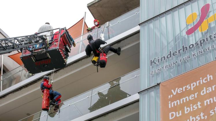 Verkleidet als Spiderman und Batman, seilen sich zwei Höhenretter der Feuerwehr Osnabrück vom obersten Balkon des CKO ab. Weitere Kollegen unterstützen auf der Drehleiter.