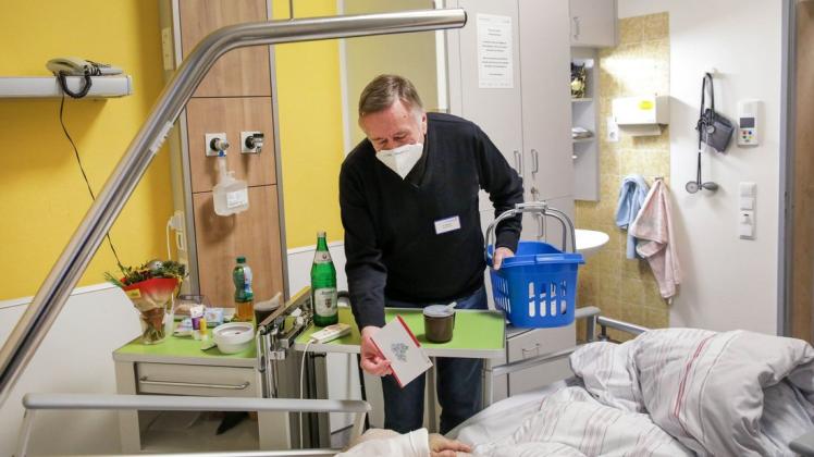 Mit einem Korb mit Spielen geht Gedächtnishelfer Alfred Bücker zu Patientinnen und Patienten mit Demenz im Marienhospital.