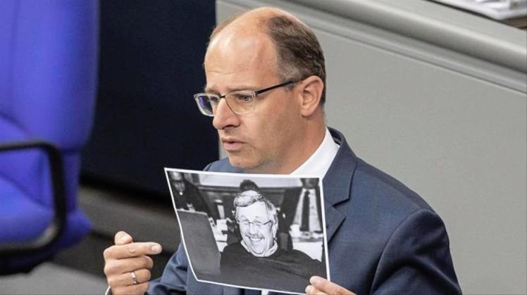 Michael Brand (CDU) hält bei seiner Rede im Bundestag ein Bild des ermordeten Kasseler Regierungspräsidenten Walter Lübcke. 