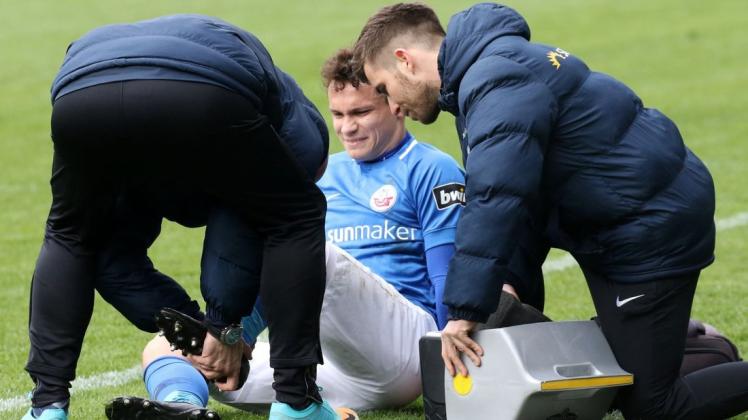 Hatte Schmerzen an der linken Ferse: Lukas Scherff. Die medizinische Abteilung des FC Hansa um Dr. Frank Bartel (links) und Jakob Kühn half, wo sie nur konnte.