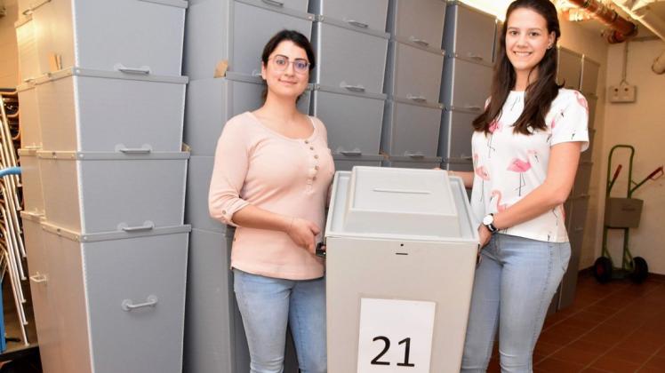 Jasmin Aras (links) und Isabell Hillmann gehören zum Wahlteam im Ganderkeseer Rathaus und präsentieren hier eine Wahlurne für den 26. Mai. Foto: Gemeinde Ganderkesee/ Hauke Gruhn