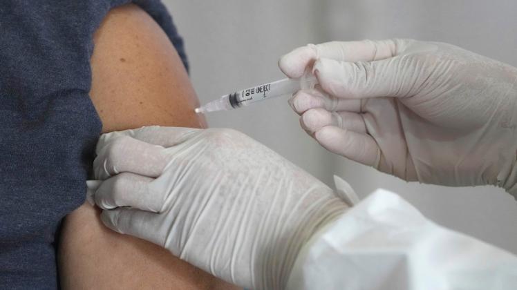 Eine medizinische Mitarbeiterin verabreicht eine Spritze mit dem Impfstoff Comirnaty gegen COVID-19 von Pfizer.