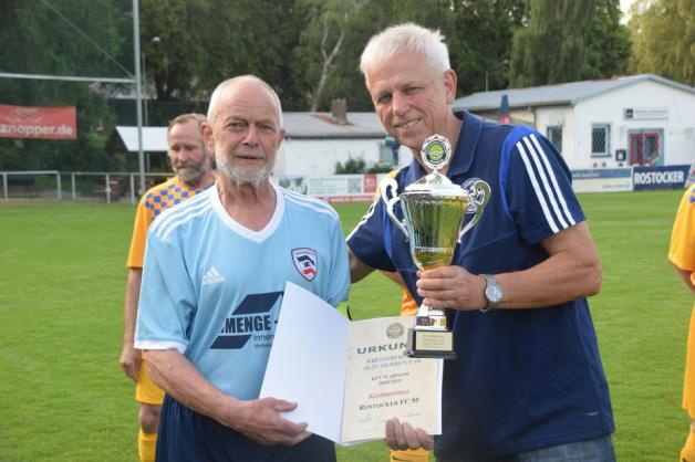 Ehrung: Staffelleiter Jürgen Runge (rechts) übergibt dem Mannschaftskapitän der Ü 60 des Rostocker FC, Olaf Jurides, den Pokal und die Urkunde zum Kreismeister-Titel.