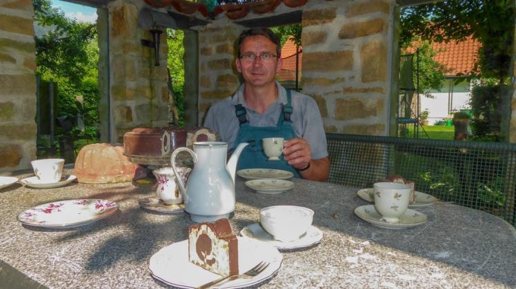 Die gedeckte Kaffeetafel mit immer frischem Beton-Kuchen hat Martin Pötter mit Geschirr aus der Mülltonne als Hingucker in seinem grünen Wohnzimmer installiert. Foto: Ursula Holtgrewe