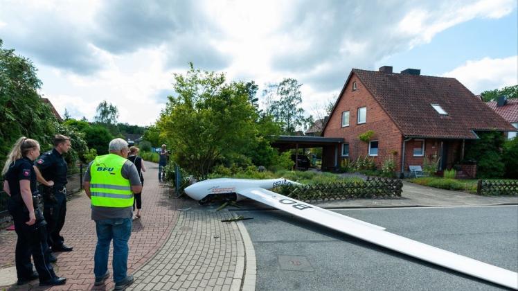 Ein zerstörtes Segelflugzeug liegt nach dem Absturz teils in einem Vorgarten und teils auf der Straße in einem Wohngebiet. Foto: dpa/Philipp Schulze