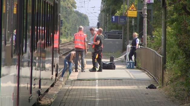 Polizeibeamte am Samstag bei Spurensuche am Bahnhof in Voerde. Foto: dpa/Guido Schulmann/tv-niederrhein