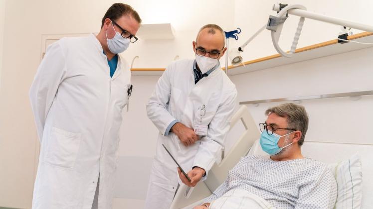 Die Thoraxchirurgen Dr. Rolf Dahmen (l.) und Dr. Sven Förster (M.) besprechen mit dem Patienten die Operation.