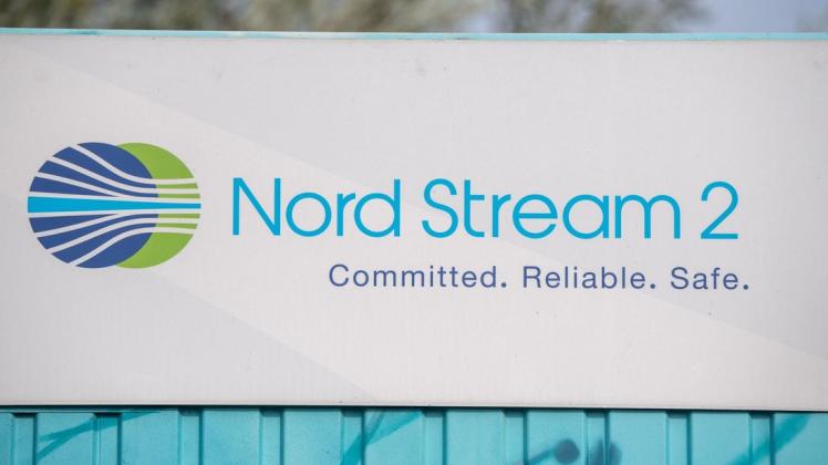 Ein Schild mit der Aufschrift "Nord Stream 2 Committed Reliable Safe" hängt im Gewerbegebiet Lubmin über einer aufgemalten Landkarte an der Erdgasempfangsstation.