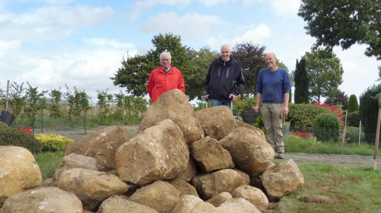 Dieter Huntebrinker, Arend Holzgräfe und Manfred Baute (von links) begutachten die aufgeschichteten Findlinge auf dem Bueraner Friedhof. Foto: Volker Tiemeyer