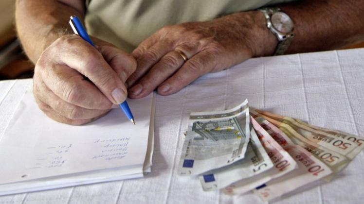 Reicht das Geld? Ein Rentner macht sich Notizen zu seinen Ausgaben.  Foto: Andreas Gebert/dpa