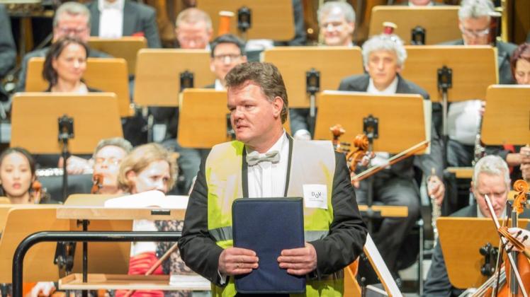 Mit ernsten Worten wendet sich Martin Goffing, Musiker der Norddeutschen Philharmonie Rostock, vor dem Konzert an das Publikum. Er macht auf die Auswirkungen des Haustarifvertrages des Volkstheaters aufmerksam.