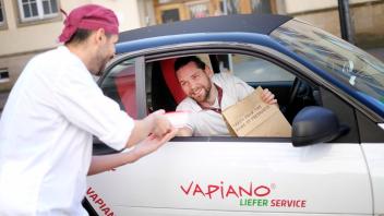 Hier liefert der Chef selbst: bei Vapiano in Rostock packen alle mit an. Derzeit werden frisch zubereitete Speisen aus der Tür heraus verkauft oder per Elektro-Smart geliefert.