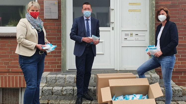 Andrea Schmidt  überreicht die FFP2-Masken an Martin Diek und Annette Werner (von rechts).