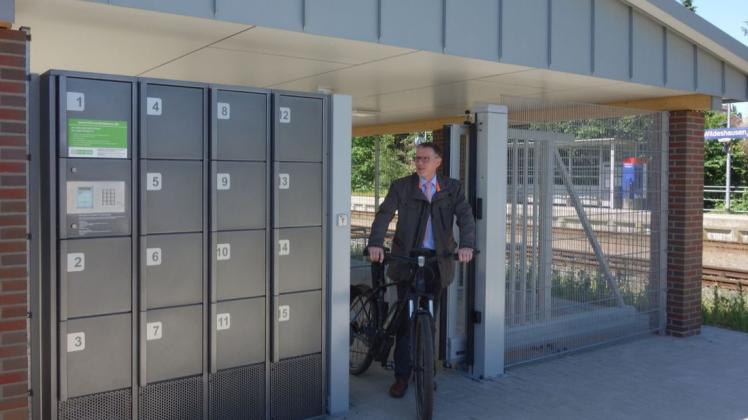 Wildeshausens Bürgermeister Jens Kuraschinski schiebt ein Fahrrad aus der neuen Bike&Ride-Anlage.