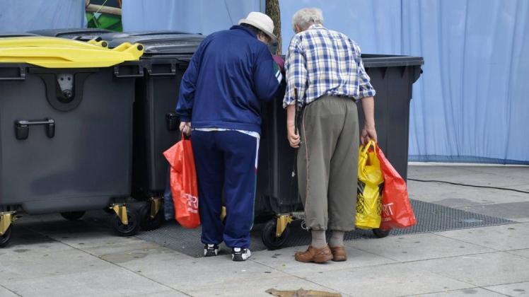 Ein älteres Ehepaar sucht in einer Mülltonne nach Pfandflaschen: Auch Rentner zählen in Deutschland zu den Gruppen, die mit am häufigsten von Armut betroffen sind (Symbolfoto).