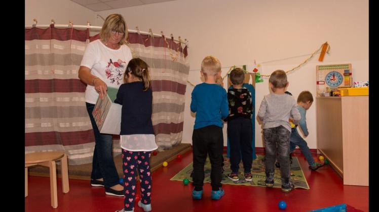 Dem Monster einen Ball zu fressen geben: Danuta Matz mit einem Tel der Kinder beim Bällewerfen.