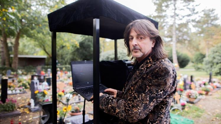 Theo Fitsos, Disc Jockey (DJ), steht mit seiner Musikanlage auf einem Lastenfahrrad neben einem frisch ausgehobenen Grab unmittelbar vor seinem Einsatz bei einer Beerdigung auf dem Friedhof Eller. Theo Fitsos, Disc Jockey (DJ), steht mit seiner Musikanlage auf einem Lastenfahrrad neben einem frisch ausgehobenen Grab unmittelbar vor seinem Einsatz bei einer Beerdigung auf dem Friedhof Eller.