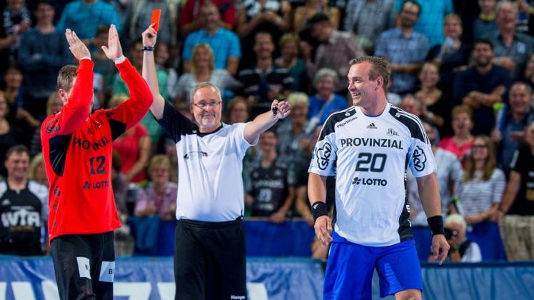 Die Handball-Schiedsrichter sollen früher härter durchgreifen, sagt DHB-Lehrwart Kay Holm, der hier selbst die rote Karte gezogen hat. In diesem Fall allerdings nur „aus Spaß“ gegen den Weltmeister von 2007 Christian Zeitz (rechts) bei dessen Abschiedsspiel im Trikot des THW Kiel. Links Torwart Andreas Palicka.