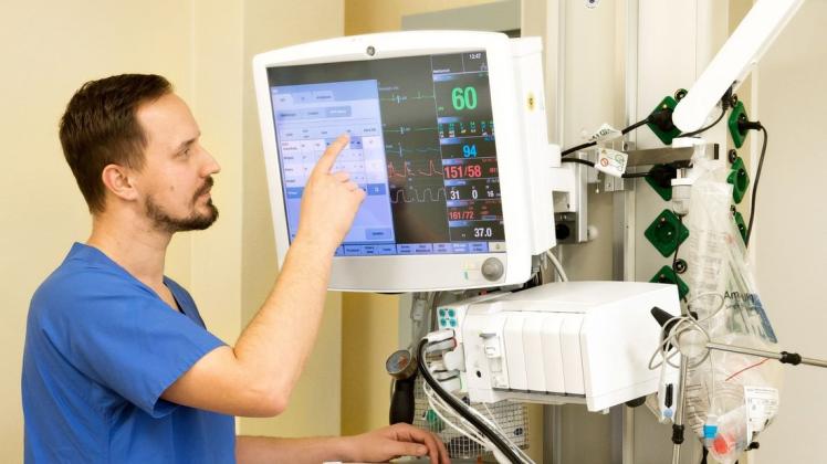 Fachkrankenpfleger Chris Wagner überprüft die Werte eines Patienten auf der Intensivstation.