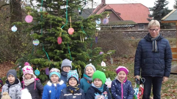Eine Reihe der Kita-Kinder und Bürgermeister Sebastian Hüdepohl am geschmückten Weihnachtsplatz auf dem Diekplatz.