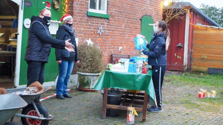 Spendenaktion mit Mindestabstand: Andreas Warneke und Angelika Stöver (v.li.) vom Delmenhorster Tierschutzhof nehmen Tierfutter von Elena Erbes entgegen.