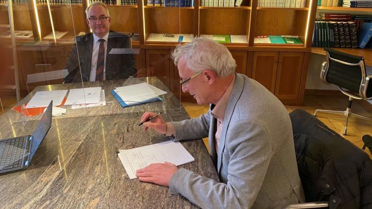 Oberbürgermeister Axel Jahnz bei der Unterschrift des Kaufvertrages in Hannover. Im Hintergrund ist der Notar Dr. Thomas Remmers zu sehen.