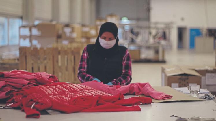 Textilien sind ihr Spezialgebiet: Eine Mitarbeiterin der Firma "RieTex" kontrolliert die Qualität von Kleidungsstücken und stellt gemeinsam mit ihren Kollegen eventuelle Mängel ab.