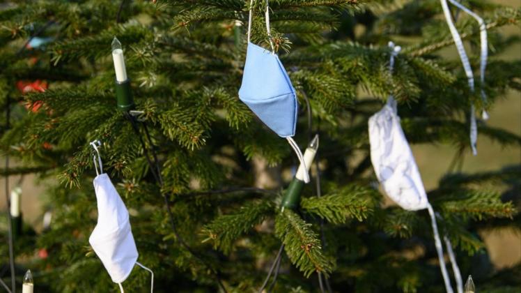 Selbst genähte Mund-Nasen-Bedeckungen hängen an einem Weihnachtsbaum.