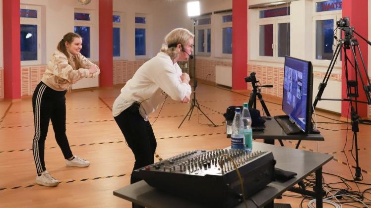Zwei Kameras nehmen das Bild auf, ein Headset den Ton. Die Teilnehmer sieht Tanzlehrerin Katja Wieczorek (rechts) auf einem Fernseher.