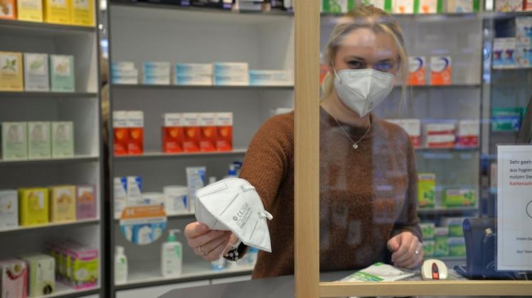 Eine FFP2-Maske hält die pharmazeutisch-technische Assistentin Lynn Leugers in der Lookenapotheke in der Hand.