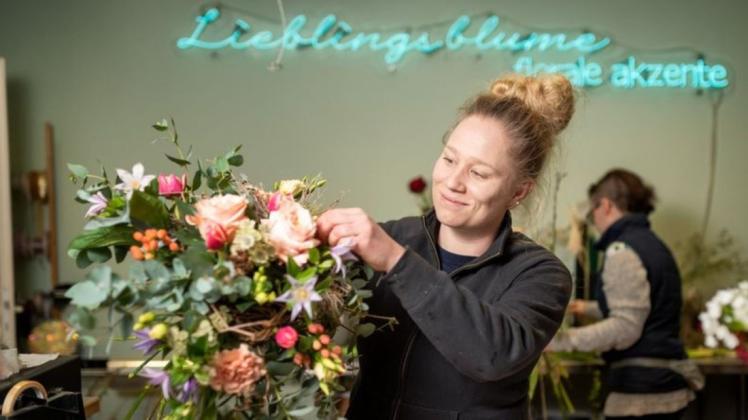 Maria Richter, Chefin der Lieblingsblume, dekoriert einen bunten Blumenstrauß. Auch ihr Geschäft leidet, trotz Öffnung, unter der Krise.