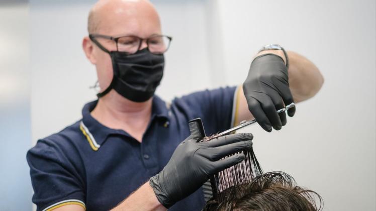 Friseur Jochen schneidet in seinem Friseursalon "Trio" dem Stammkunden Stefan die Haare. Ab Montag (1. März) dürfen Friseurbetriebe ihr Geschäft unter strengen Hygiene- und Zutrittsauflagen wieder für Kunden öffnen.