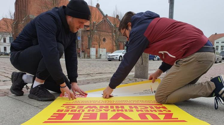 Alexander Schenk (l.) und Stephan Klemmer von der Print-Werbeagentur in Boizenburg waren mit vollem Eifer dabei, als es an das Aufkleben der großen Bodenaufkleber zum Aktionstag „Vorsicht, Vorurteile!“ ging.