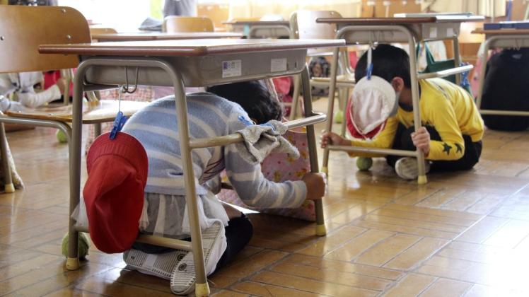 In Japan bebte am Samstagabend die Erde. Grundschüler suchen Schutz unter ihren Tischen während einer Erdbeben-Notfallübung. (Symbolbild)