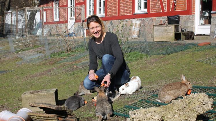 Mandy Schmidt vor ihrem Reetdachhaus in Quarnbek. Für das Foto gibt es Gemüse für die Kaninchen.