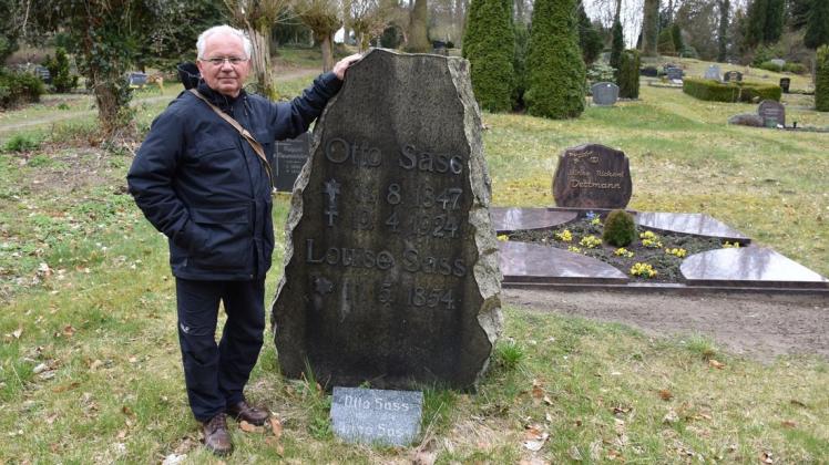 Der Historiker Gerhard Schotte steht am Grab von Otto und Luise Sass auf dem Gadebuscher Friedhof. Ein 1,60 Meter hoher Findling dient als Grabstein.