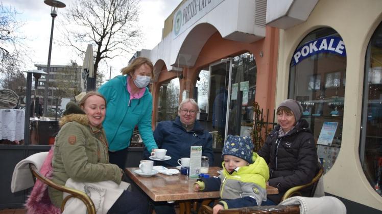 Die Inhaberin des Pressecafés in der Uetersener Fußgängerzone Ricarda Plath (Zweite von links) freut sich, im Außenbereich ihres Cafés wieder Gäste begrüßen zu dürfen.