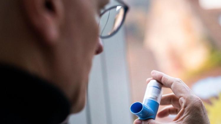 Ein Asthmatiker hält ein Asthmaspray in der Hand.