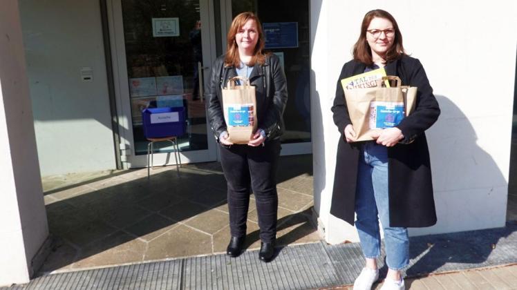 Carolin Renkewitz (l.) und Johanna  Gumz mit den Medientüten für die Ausleihe to go