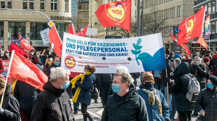Auch in diesem Jahr gab es wieder Protest: Ostermarsch-Teilnehmer in Hamburg halten ein Transparent mit der Aufschrift "Mehr Geld für Erziehungs- und Pflegepersonal statt für Aufrüstung und Krieg!"