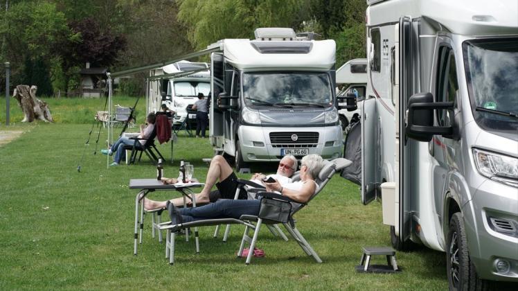 Camper liegen vor ihrem Wohnmobil in der Sonne. Besonders in den nördlichen Bundesländer liegen Wohnmobile voll im Trend.