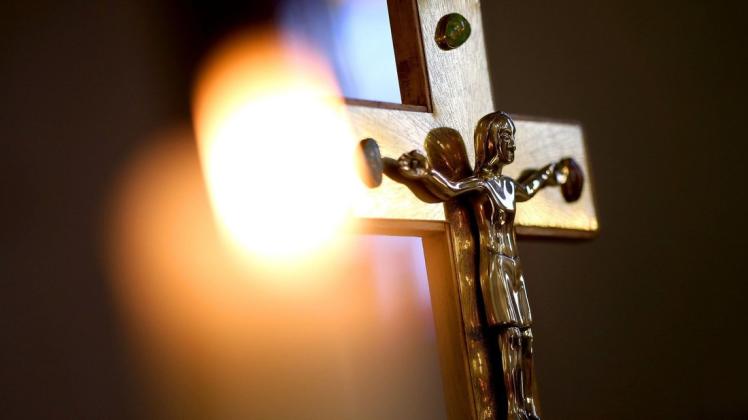 Ein Jesuskreuz und eine brennende Kerze erinnert an Verstorbene.