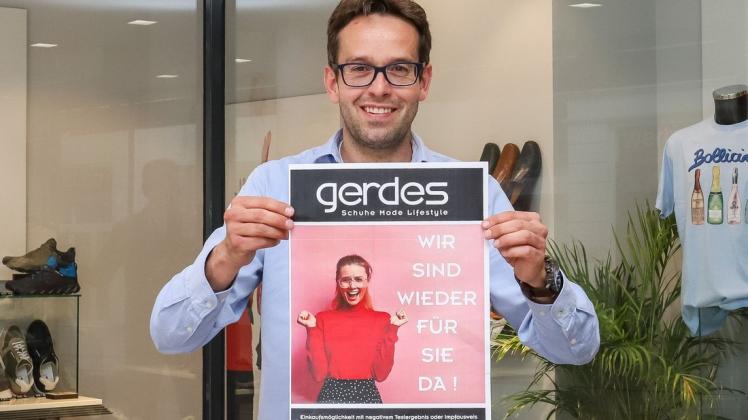 Die Plakate sind gedruckt: Marc Engels vom Schuhhaus Gerdes darf wieder Kunden in seinem Geschäft begrüßen – wenn auch mit Auflagen.