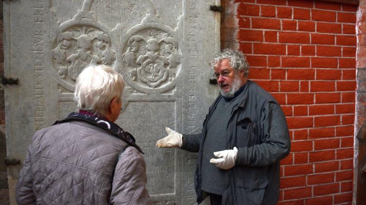 Boris Frohberg erklärt Irene Fahrenheim detailliert, wie er bei der Restaurierung der Grabplatte vorgeht.